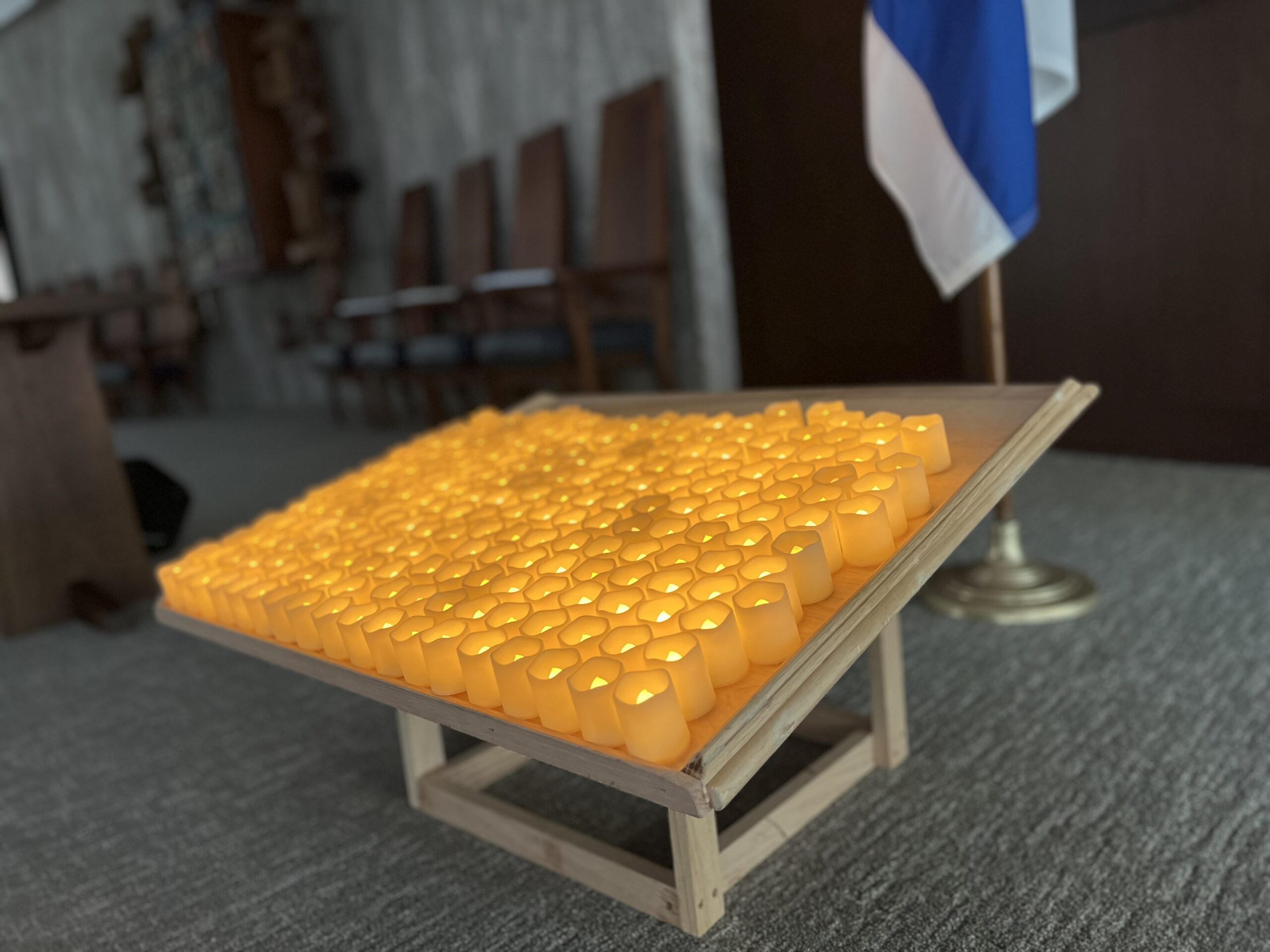 Bring Them Home Now. A vigil of candles sits on our sanctuary’s bimah for the hostages held by Hamas and its partners in Gaza.